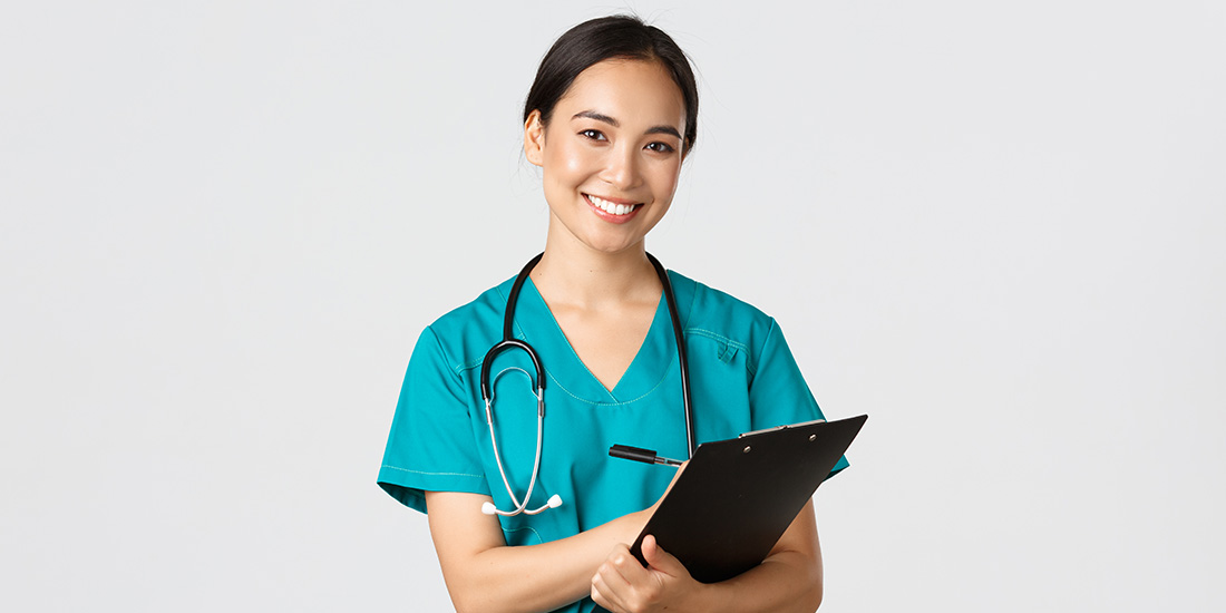 Caregiving nurse holding a clipboard with a stethoscope around her neck