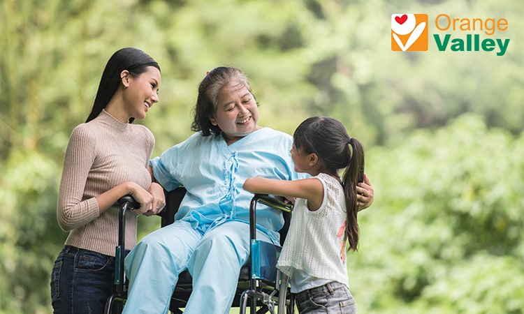 Family supporting elderly loved one in a wheelchair