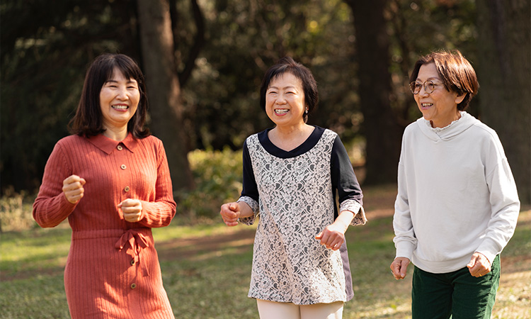 Three active senior women jogging outdoors to maintain health.